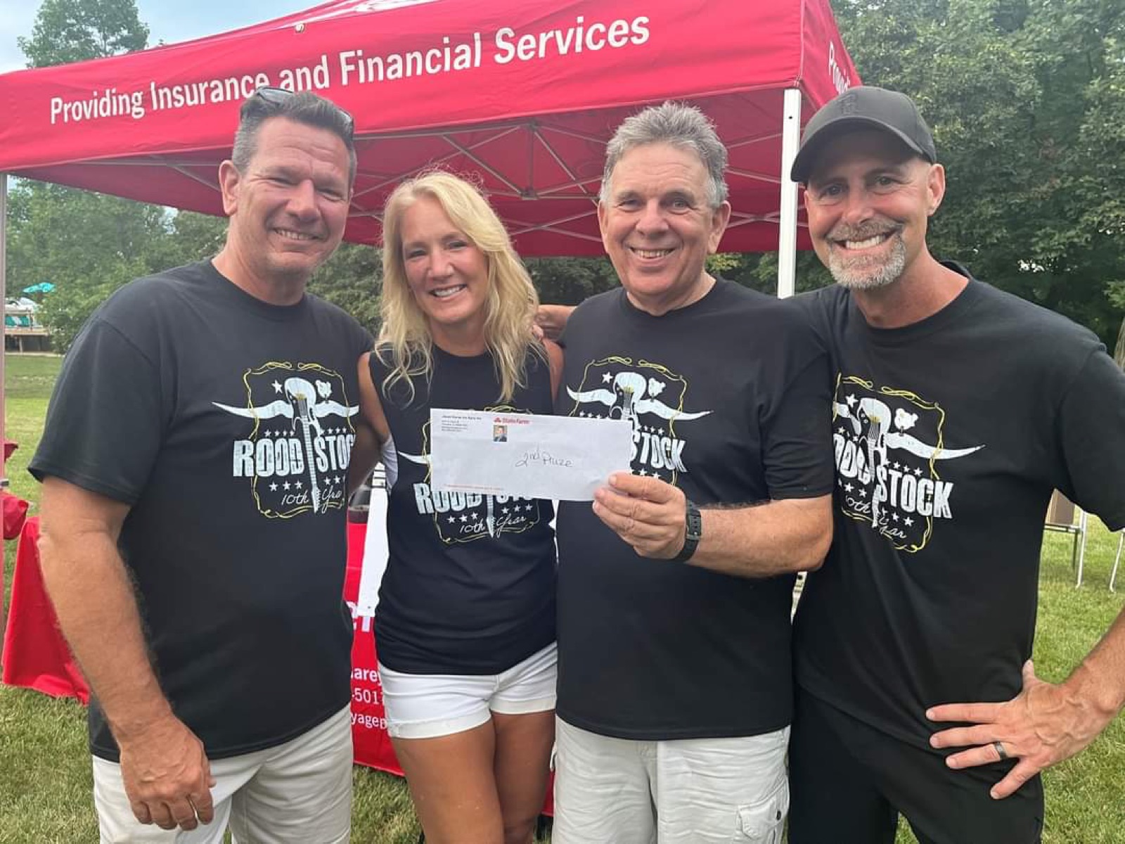 Roodstock crew presenting a donation check in matching t-shirts